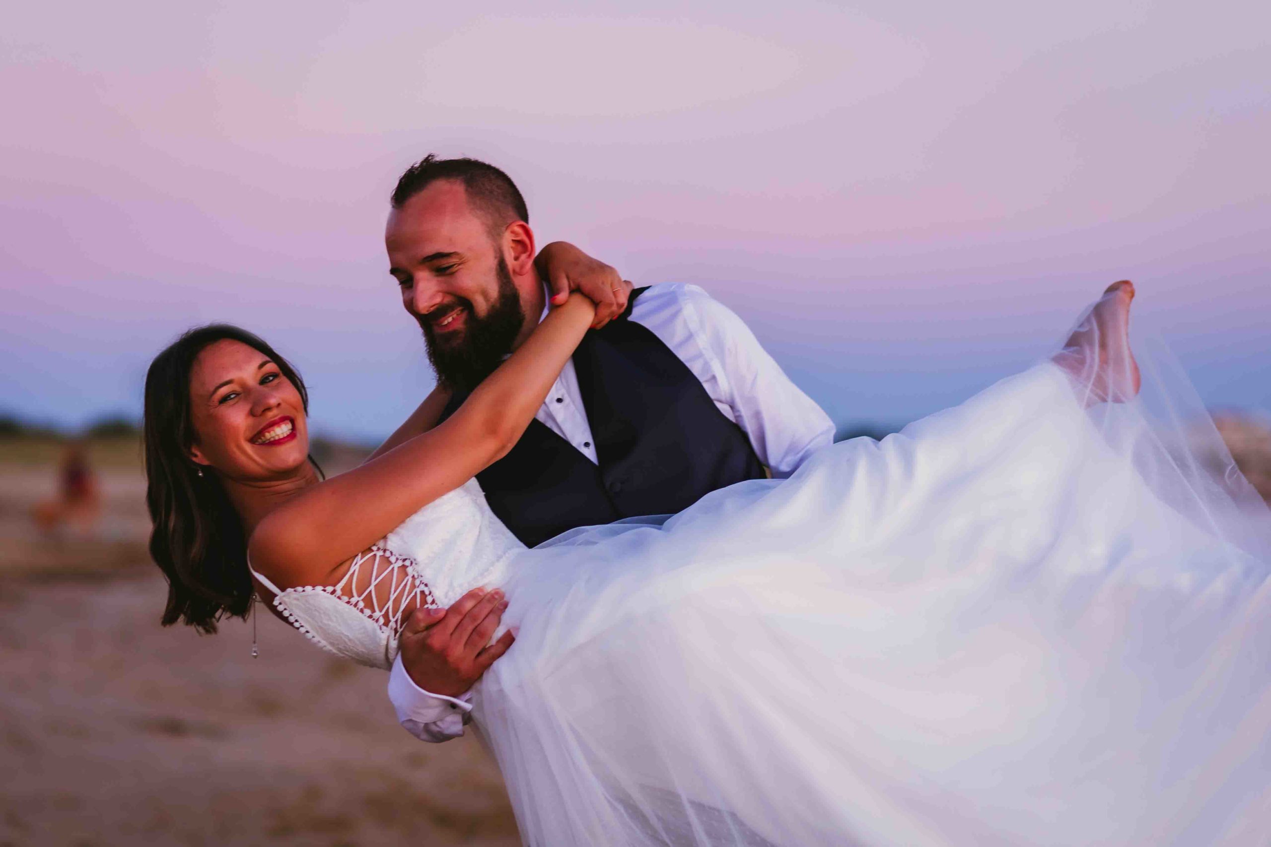 Photographe Mariage Le marié tient la mariée dans les bras sur une plage de Vendée