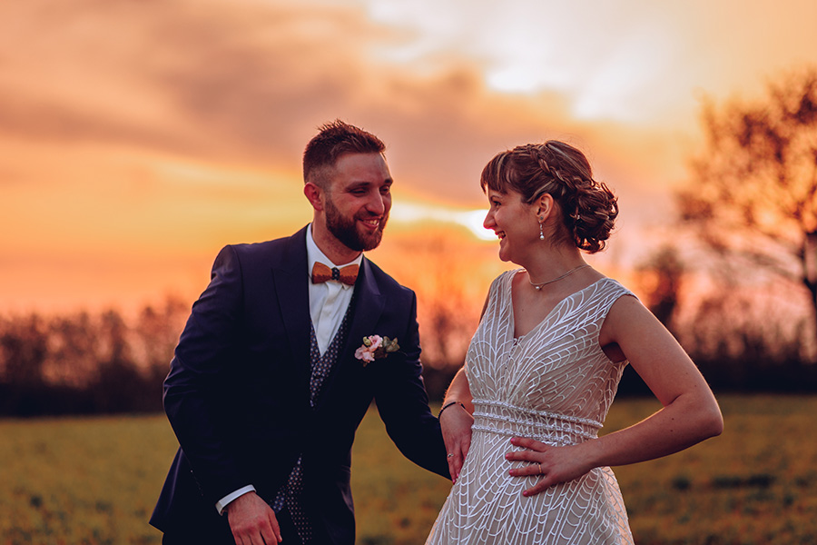 Le marié chatouille la mariée pour la séance photo avec leur photographe de mariage aux Sables d'Olonne