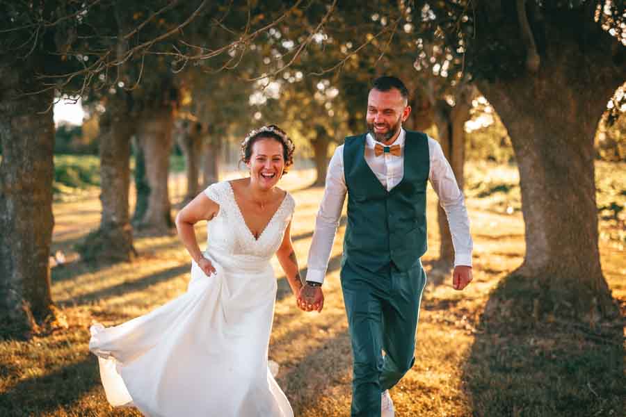 Les mariés courent pour leurs photos de mariage à Fontenay le Comte en Vendée