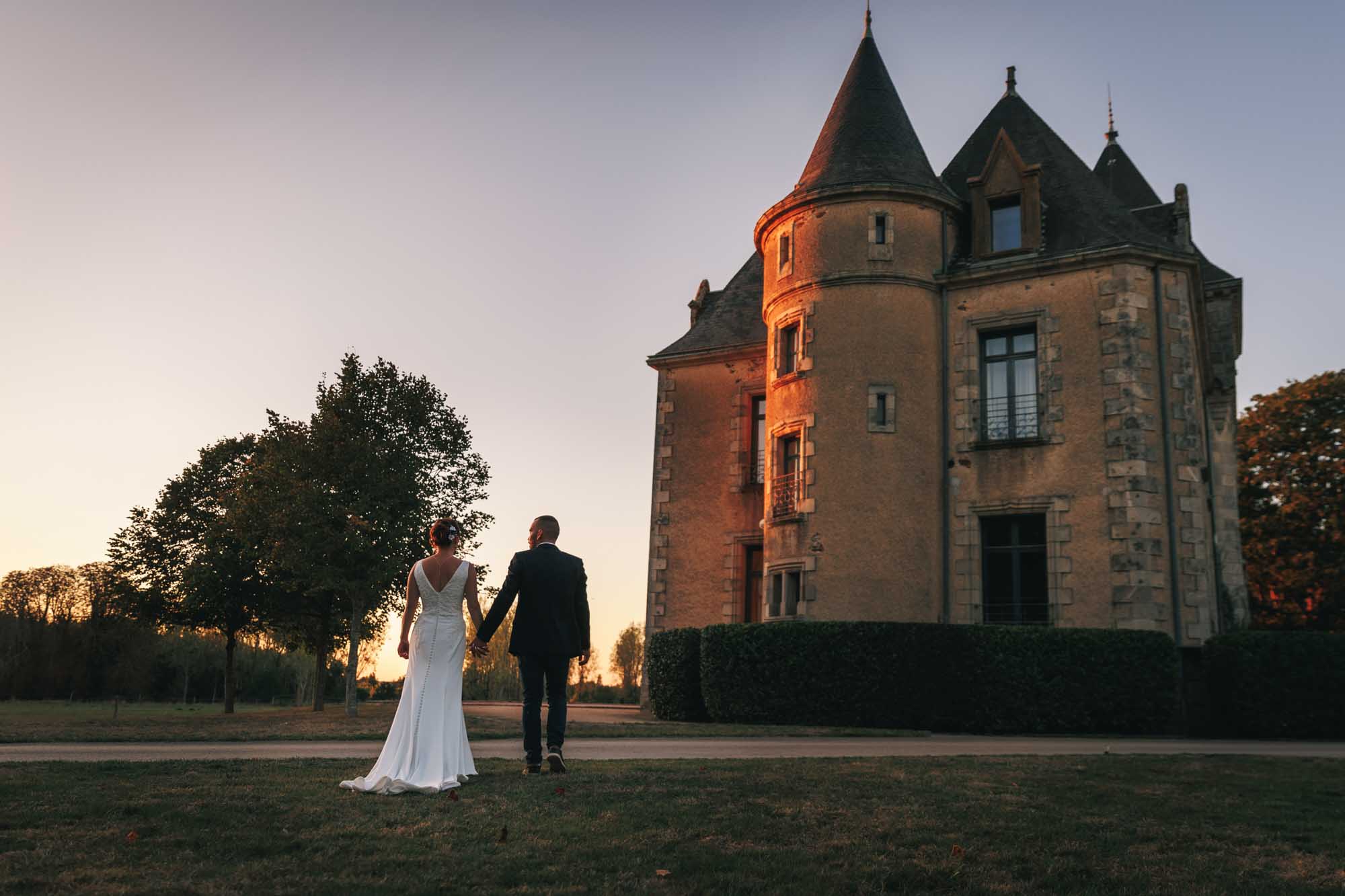Les mariés marchent vers le château pour leurs photos de mariage aux Sables d'Olonne en Vendée