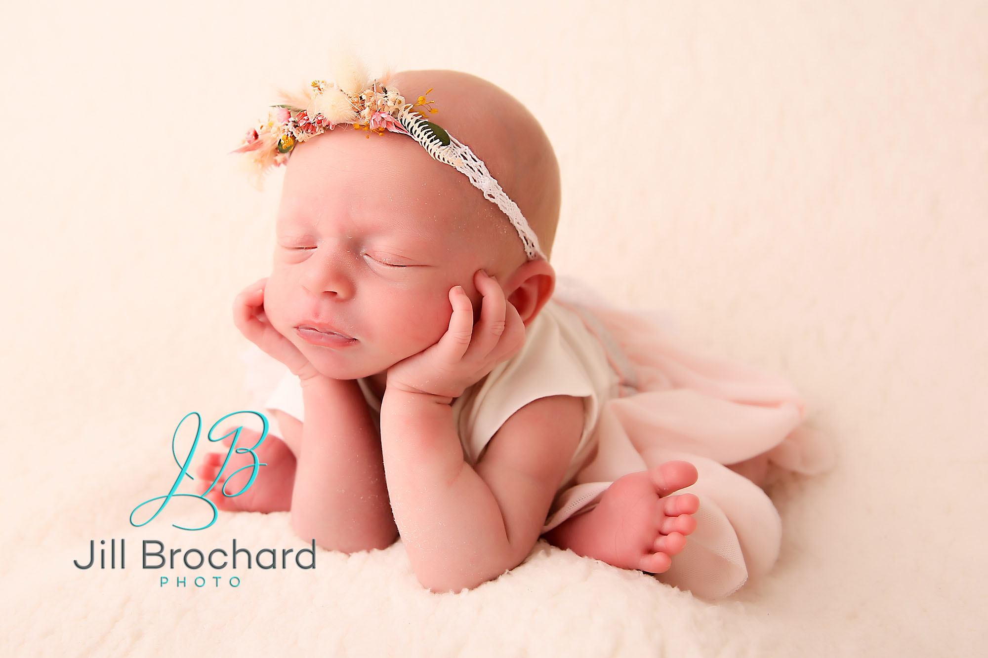 Un bébé tient sa tête pour son photographe de naissance
